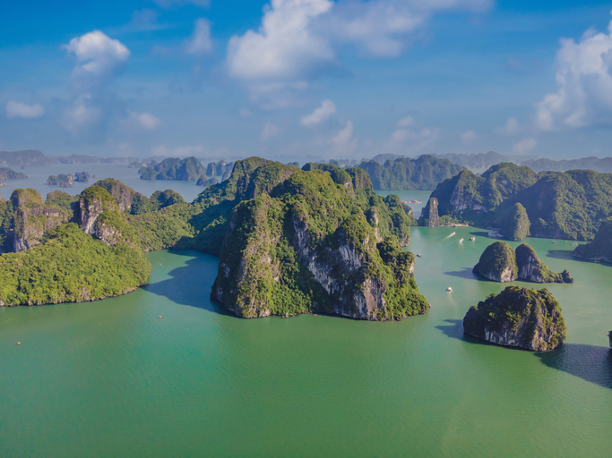 Aerial view panorama of floating fishing village and rock island, Halong Bay, Vietnam, Southeast Asia. UNESCO World Heritage Site. Junk boat cruise to Ha Long Bay. Popular landmark of Vietnam.