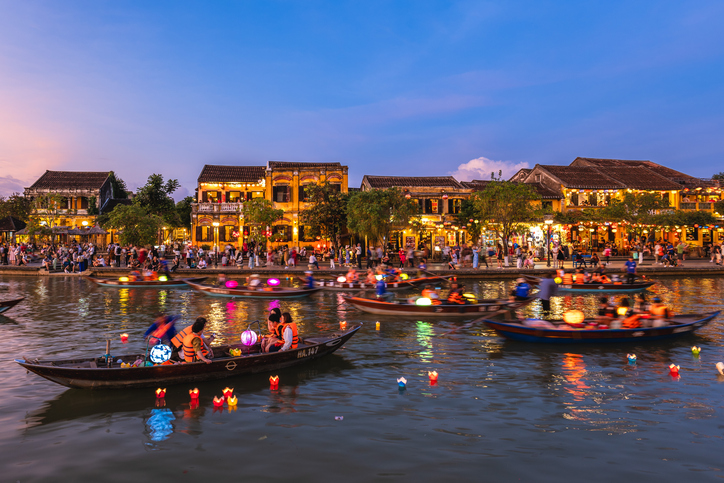 January 14, 2024: People ride boats and release paper flower lanterns at Thu Bon River in the Hoi An ancient town, Vietnam at night to pray for the best.