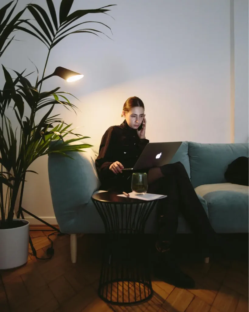 Opiekun podróży siedzi na kanapie i rozmawia z klientem przez telefon